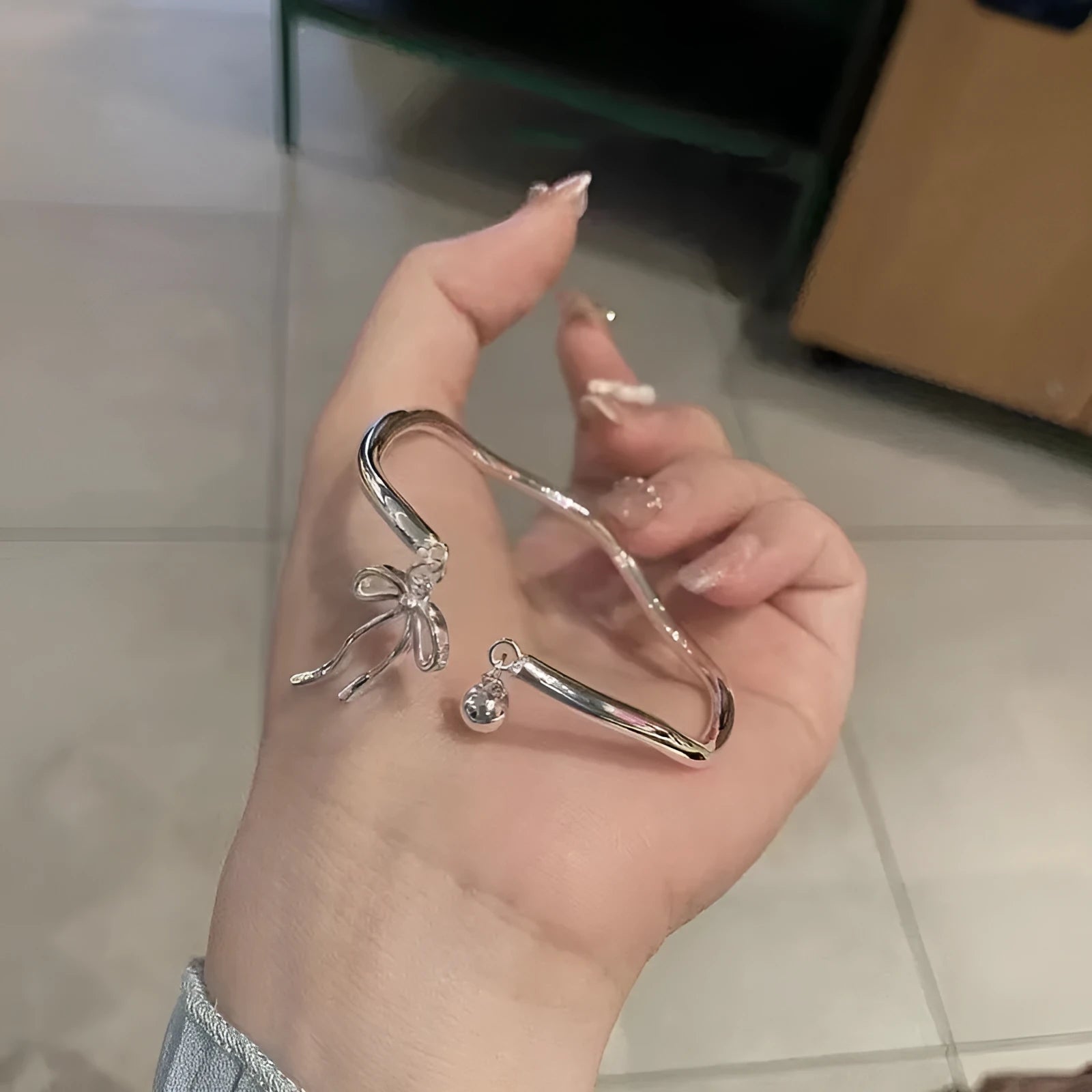 Silver bow adjustable girlfriends bracelet with bell opening clasp and sliding charm