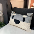 Grey or white West Highland puppy shaped pillow on a sofa, 50cm long.