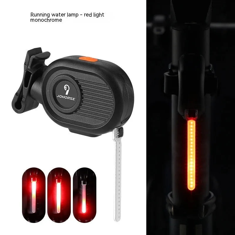Bicycle rear safety taillight displaying a colourful running water or waterfall light effect on a black background.