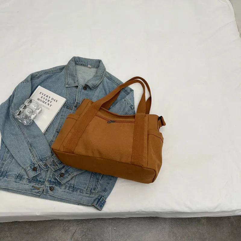 Large polyester canvas shoulder tote bag in solid colour with outer pocket and shoulder strap
