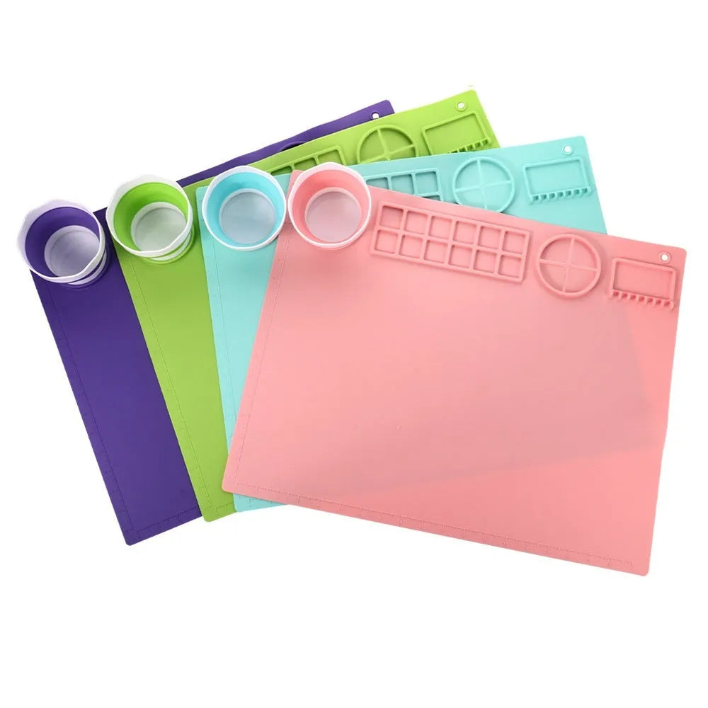 Green silicone painting mat measuring 50 by 40 centimetres with two round bowl wells for holding water or paint.