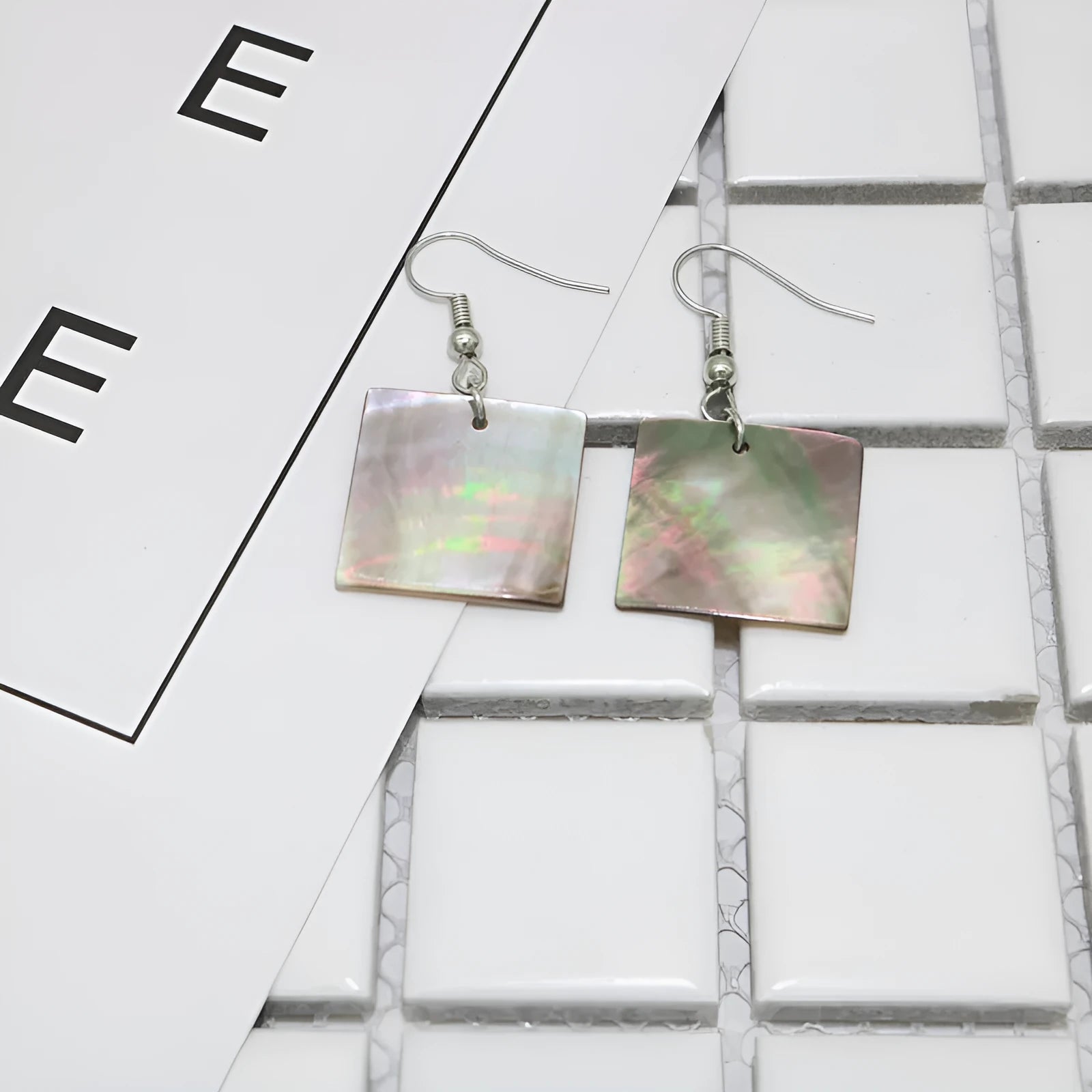 A pair of women's geometric earrings made from natural shell in a retro style.