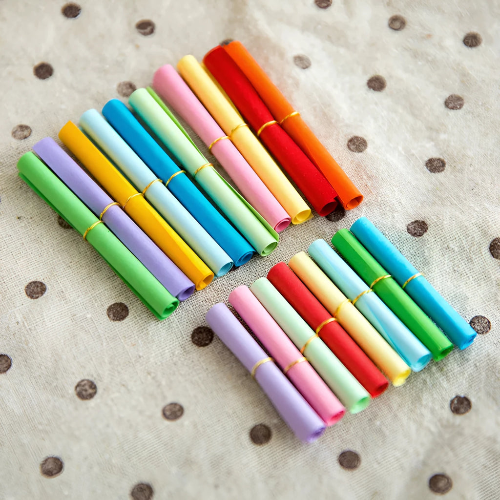 Assorted colourful scroll-style paper notes with metal eyelets in four different sizes.