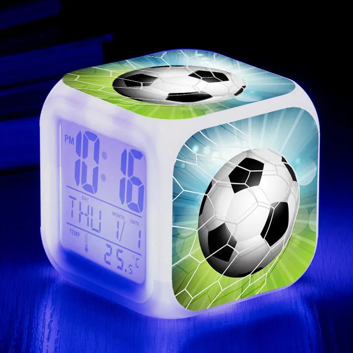 Square plastic alarm clock with a cartoon football pattern, showing silent vibrating alarm models.