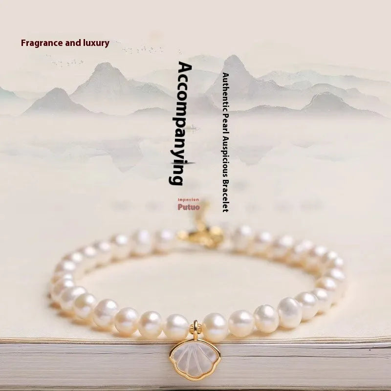 Women's freshwater pearl bracelet with fan-shell alloy clasp in 16cm size on wrist.
