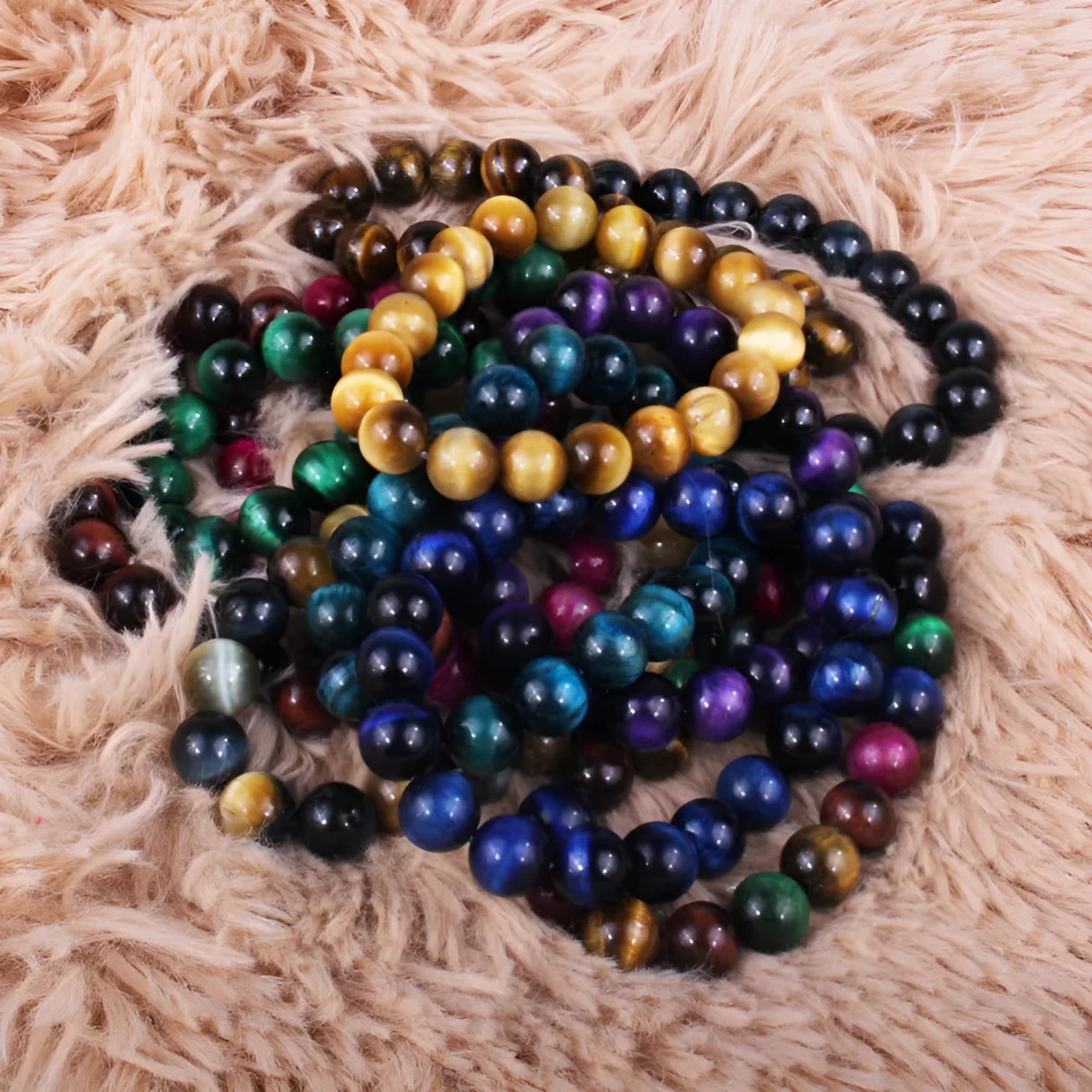 Tiger eye crystal stone bracelet showing round beads available in multiple colours and sizes on a wrist.