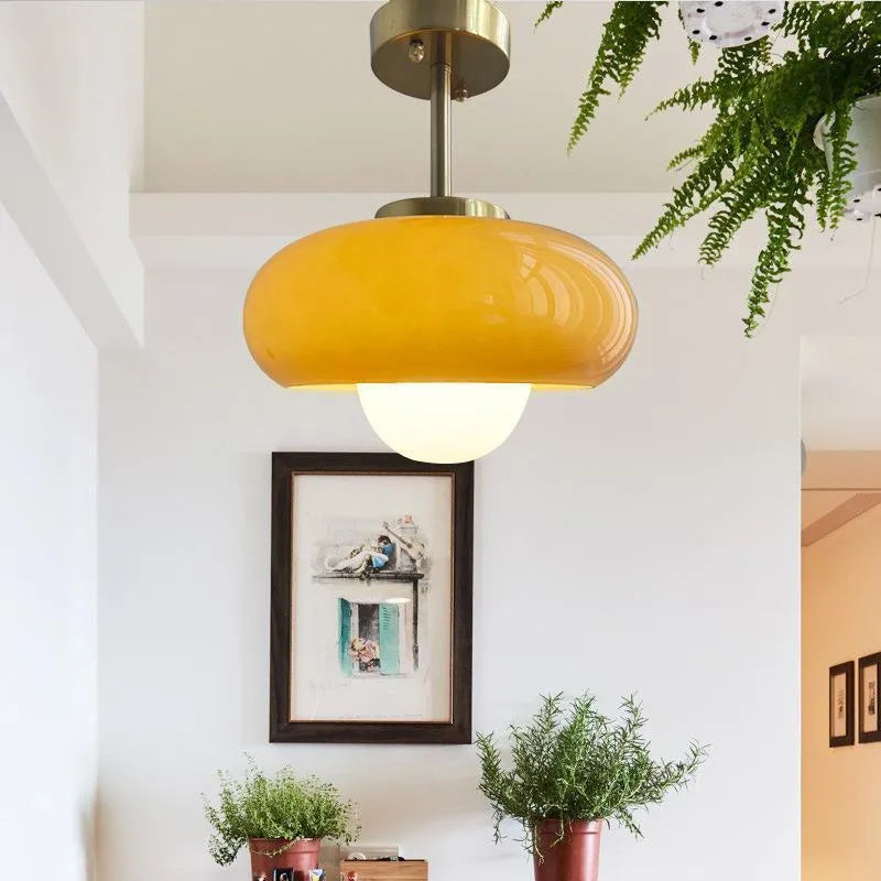 Three-headed Bauhaus pendant light with milky white glass egg tart shades hanging from a ceiling.