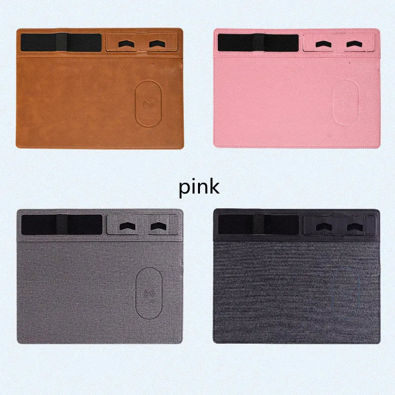 Pink wireless charging mouse pad with phone holder on a desk, showing USB cable connection