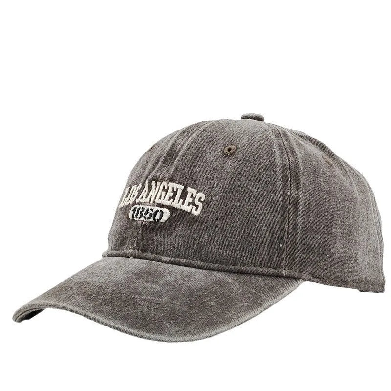 Retro washed distressed embroidered peaked cap with adjustable strap on a conical crown.