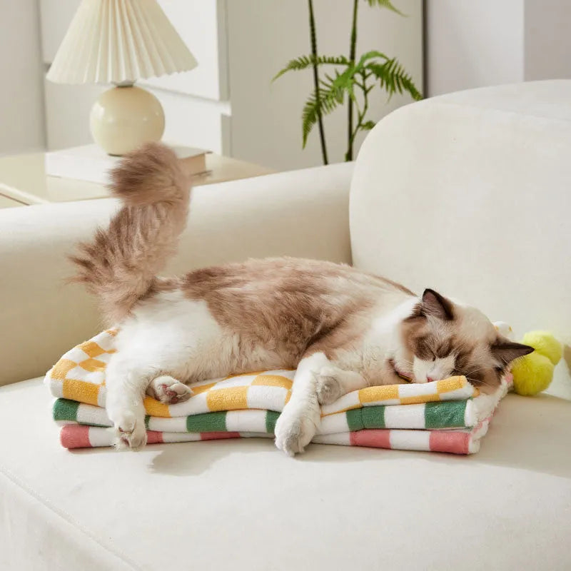 Green plaid plush pet blanket for dogs and cats on a sofa