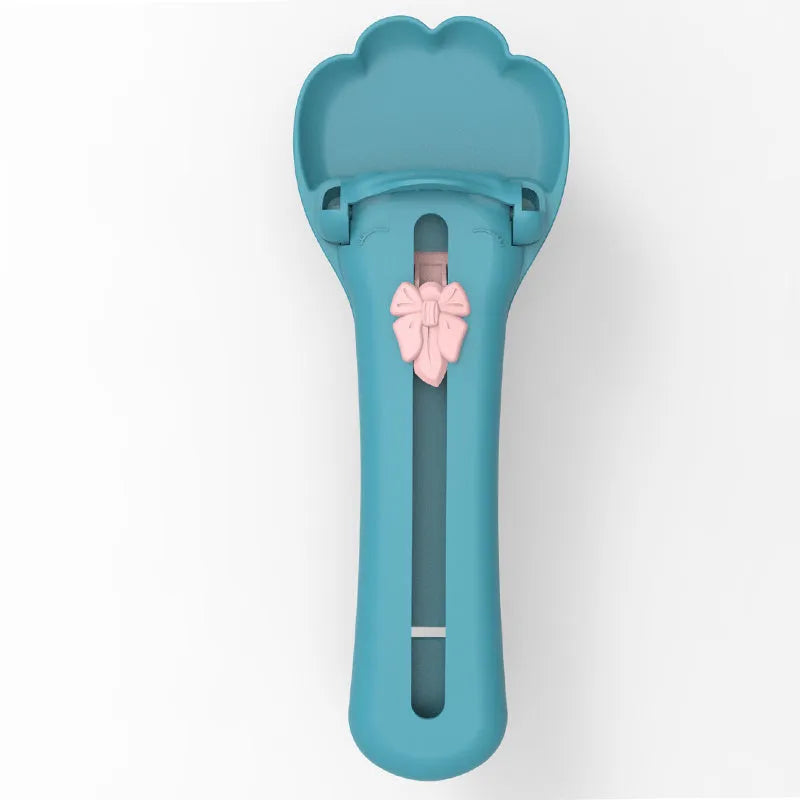Green and pink plastic pet food scoop with squeeze mechanism for dispensing treats and liquid food