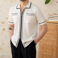 Man wearing a slim black polo shirt with a lapel collar and short sleeves.