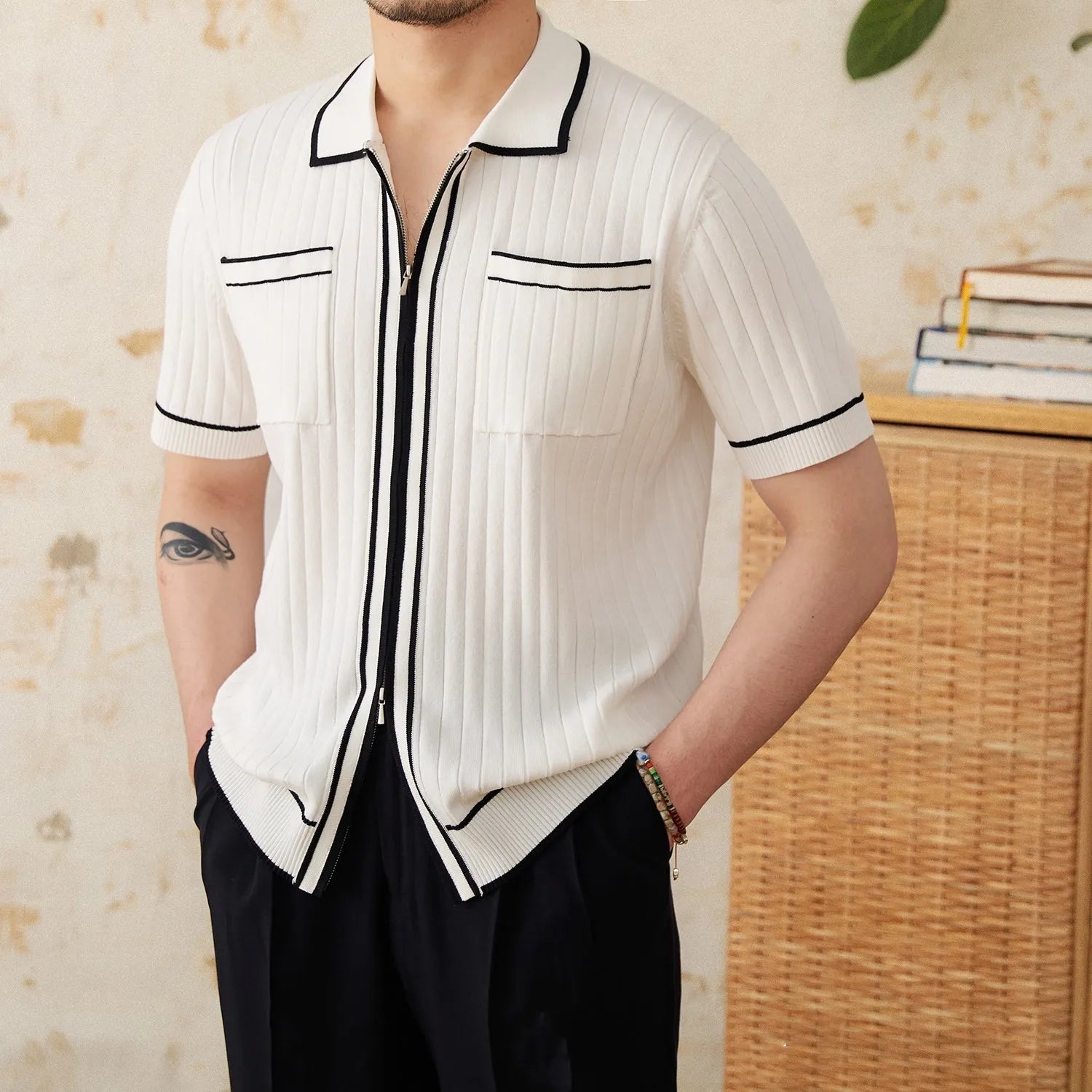 Man wearing a slim black polo shirt with a lapel collar and short sleeves.