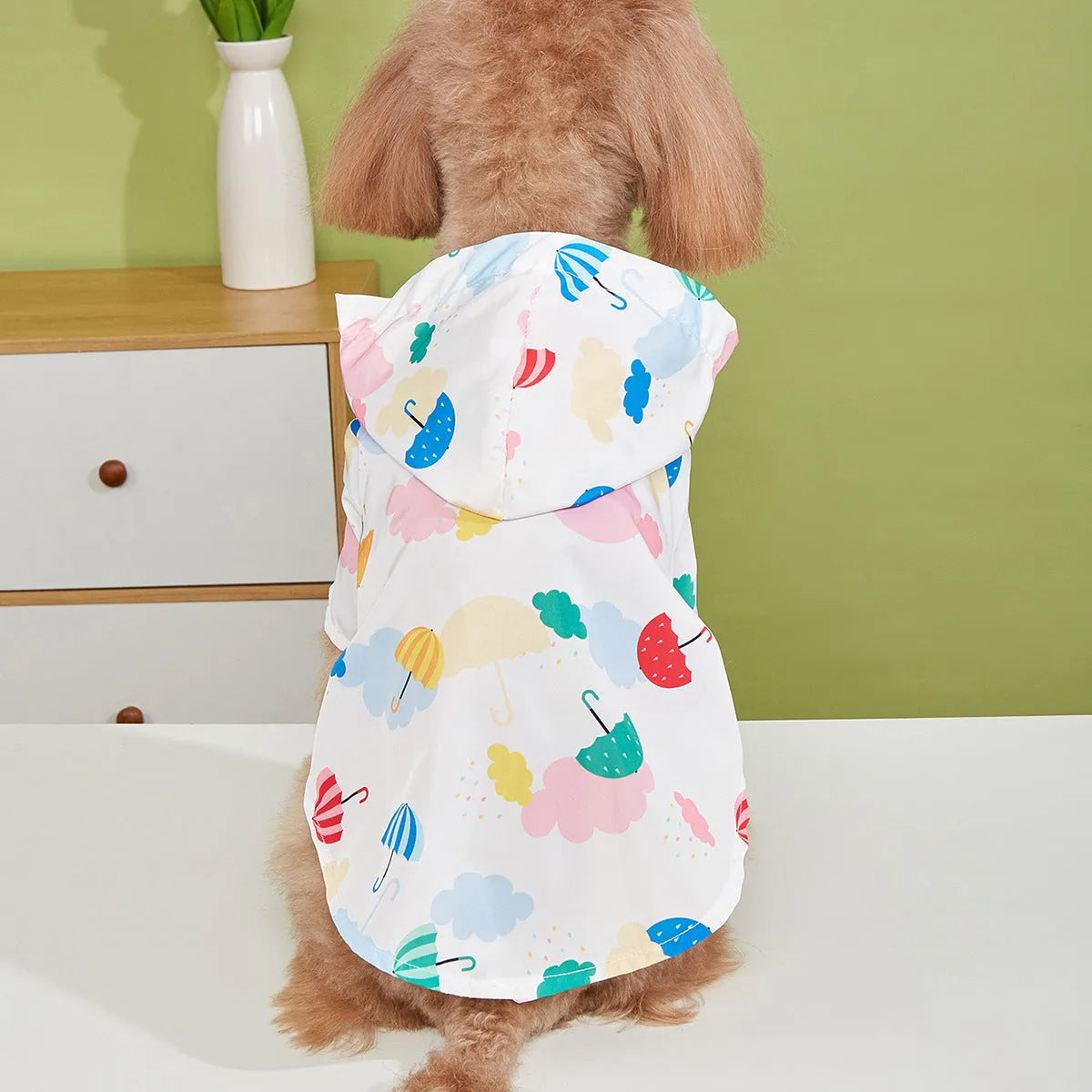 Colourful cartoon umbrella print dog raincoat in polyester fabric.