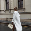 White longline knitted cardigan jacket with regular sleeves on a model.