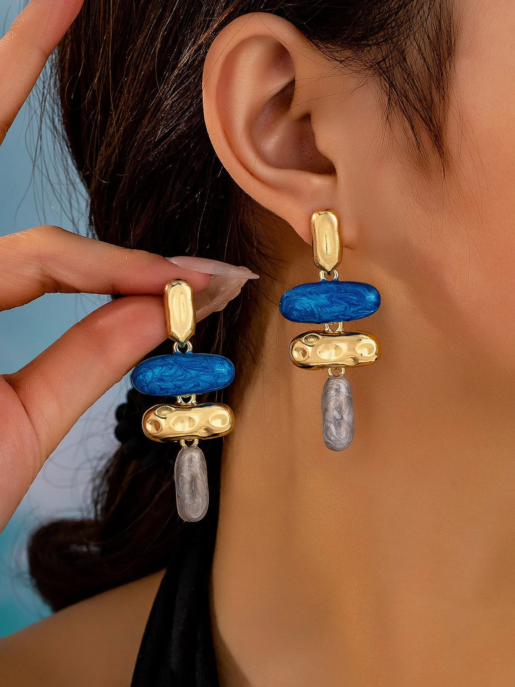 A pair of simple geometric stud earrings with a multicolour metallic finish.