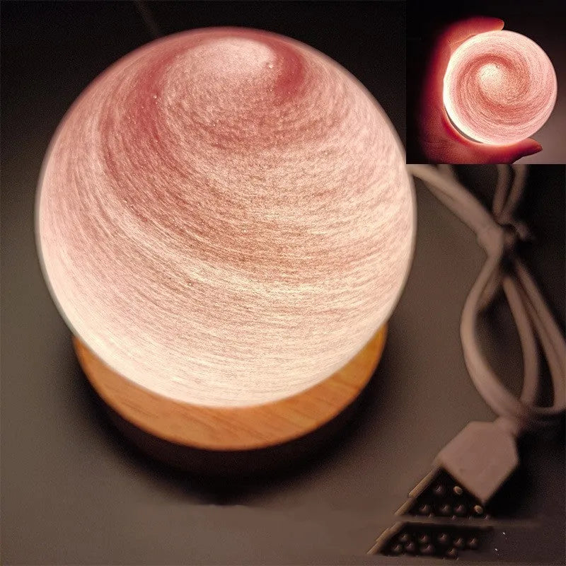 Planets themed USB night light with modern design and three-colour dimming on bedside table.