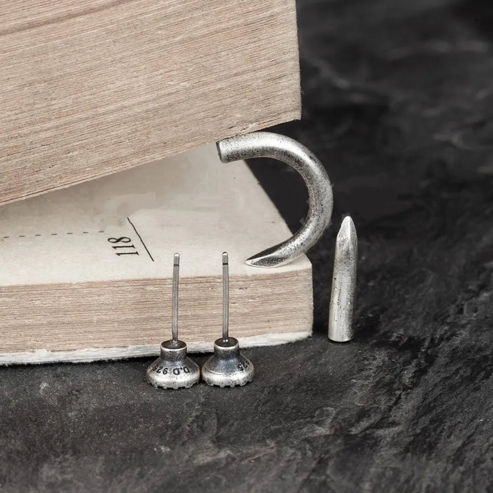 S925 sterling silver nail-shaped stud earrings on a plain background, showing straight and curved style options.
