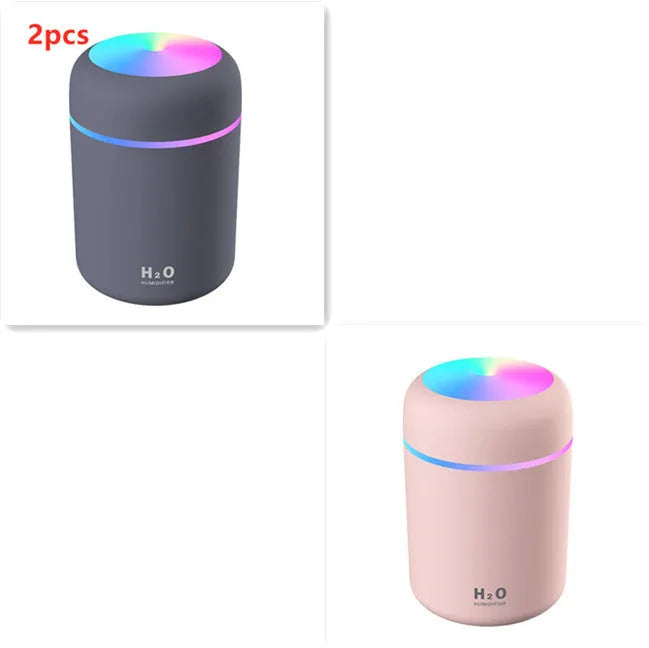 Pink USB mini humidifier with LED lights and water tank on desk