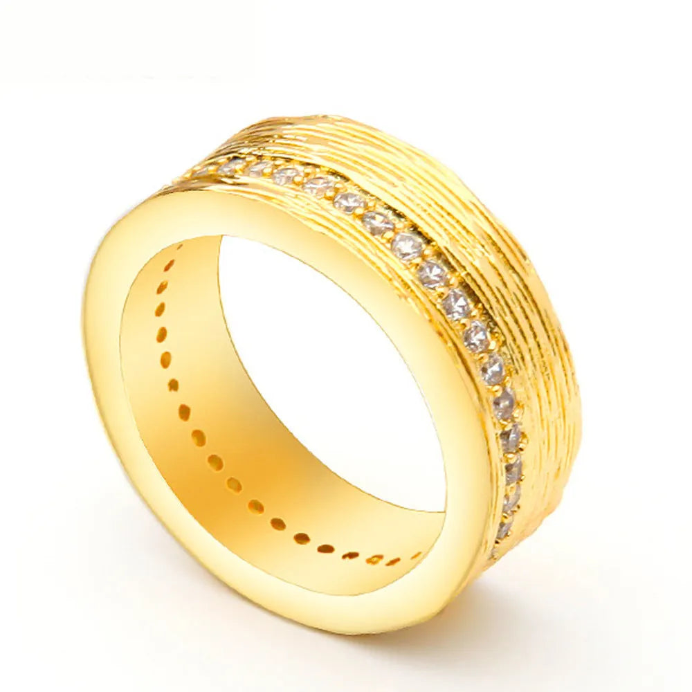 Gold coloured geometric zircon ring for women on a plain background, showing its structured shape.