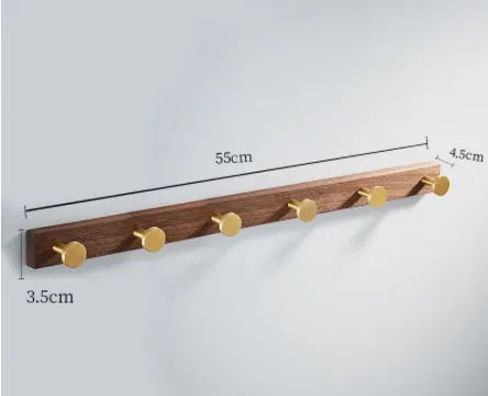 Black walnut bathroom clothes hook row with brass-finished aluminium hooks in perforated mounting design