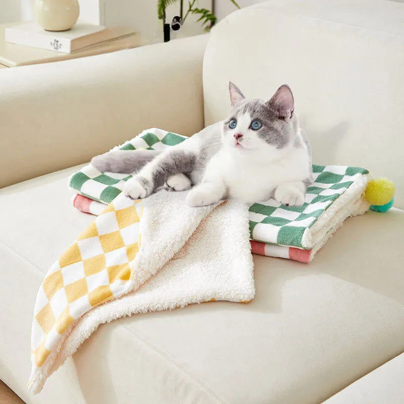 Green plaid plush pet blanket for dogs and cats on a sofa