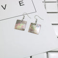 A pair of women's geometric earrings made from natural shell in a retro style.