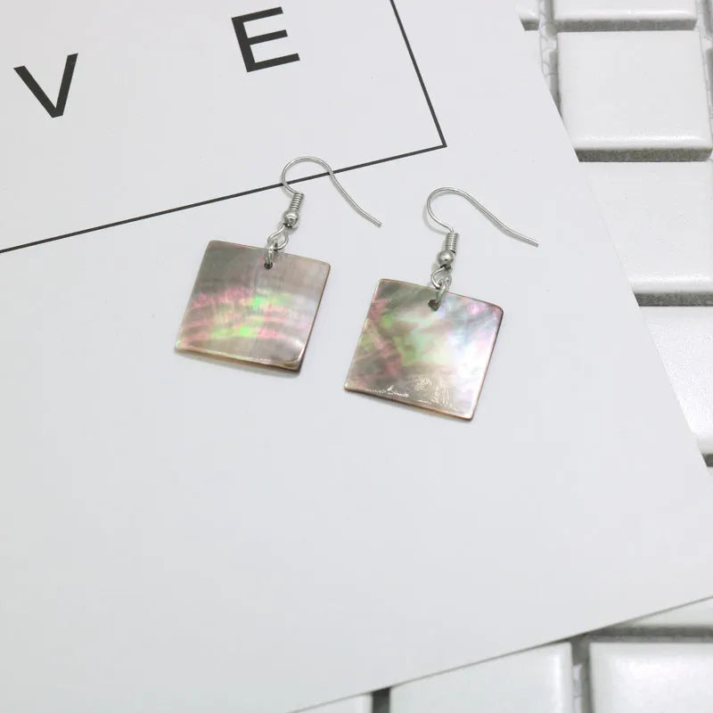 A pair of women's geometric earrings made from natural shell in a retro style.