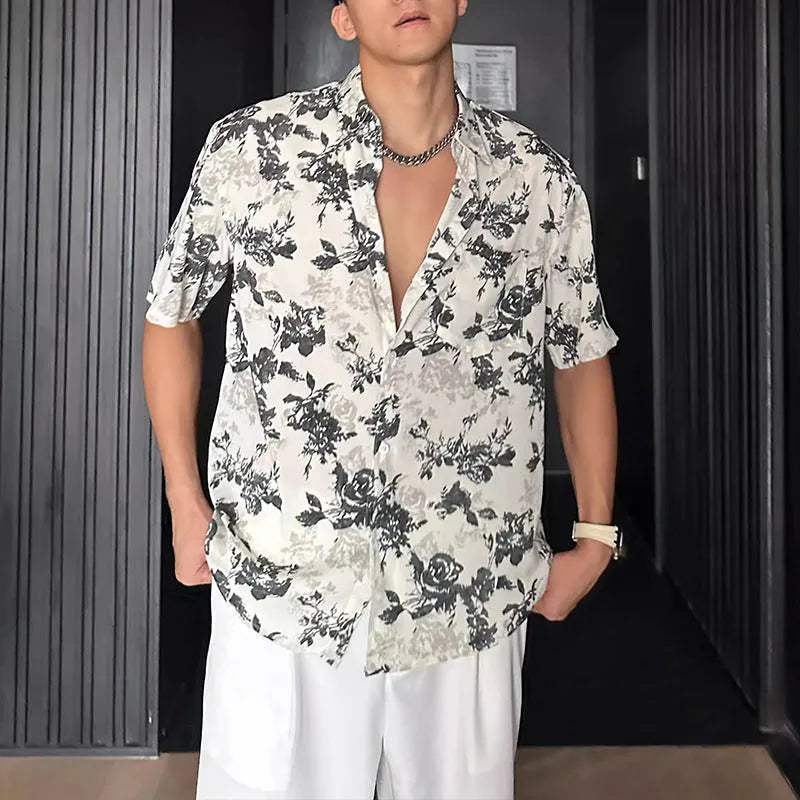 Man wearing a loose black floral print short sleeve casual shirt with a cardigan style open front.