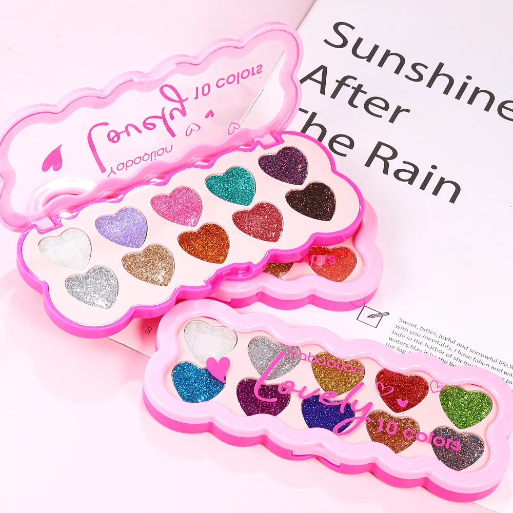 Heart-shaped case open to show ten eyeshadow pans in white, beige, pink, purple, brown, blue, black, royal blue, maroon, and coral.