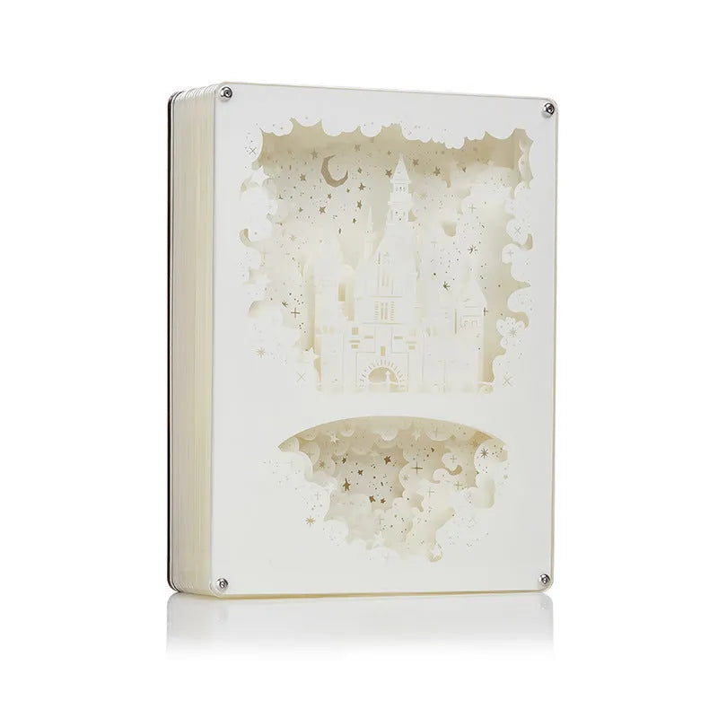 Modern bedside USB night light with paper carving design and remote control on a table.