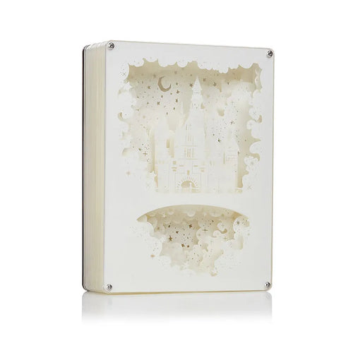 Modern bedside USB night light with paper carving design and remote control on a table.
