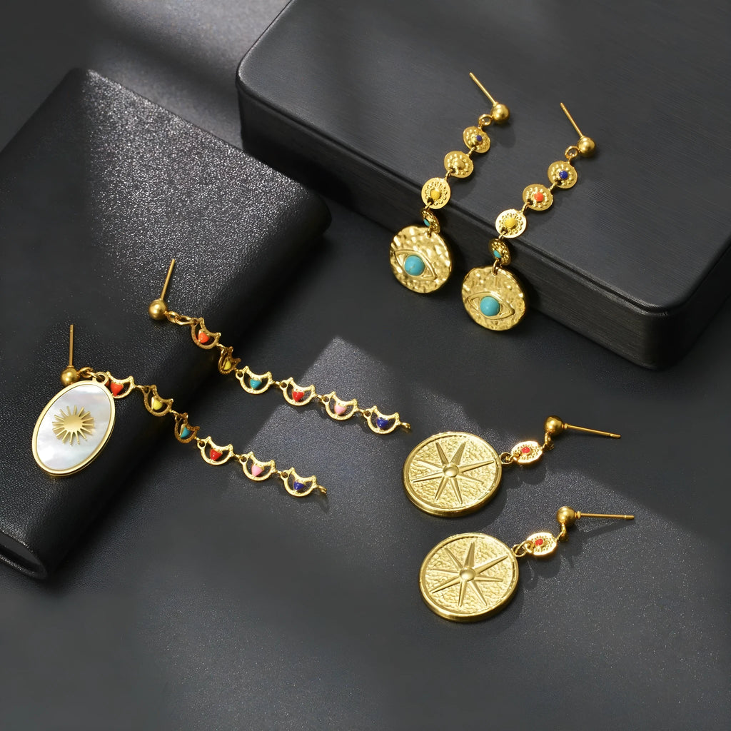 Geometric stainless steel drop earrings showing star, eye and shell sun designs for pierced ears
