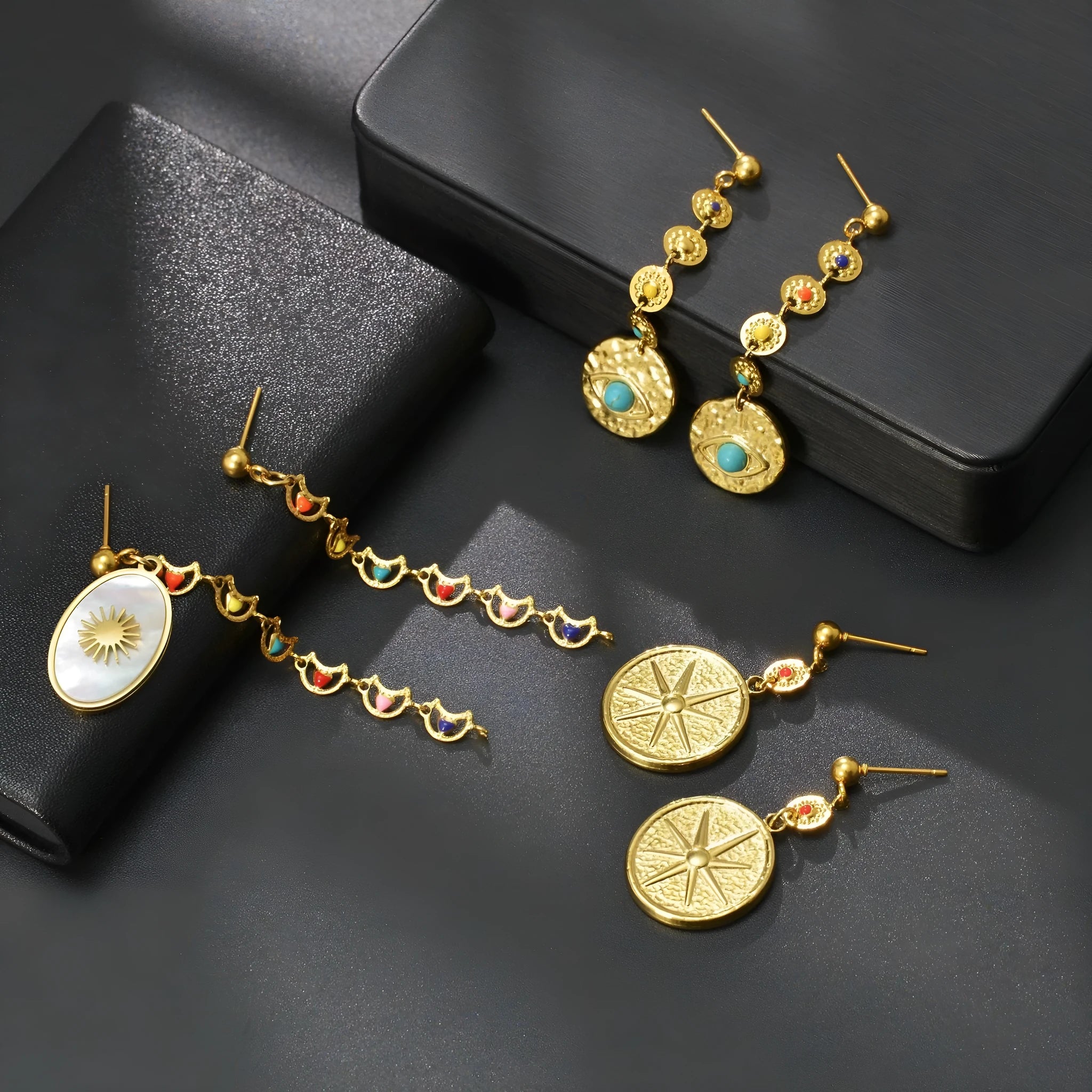 Geometric stainless steel drop earrings showing star, eye and shell sun designs for pierced ears
