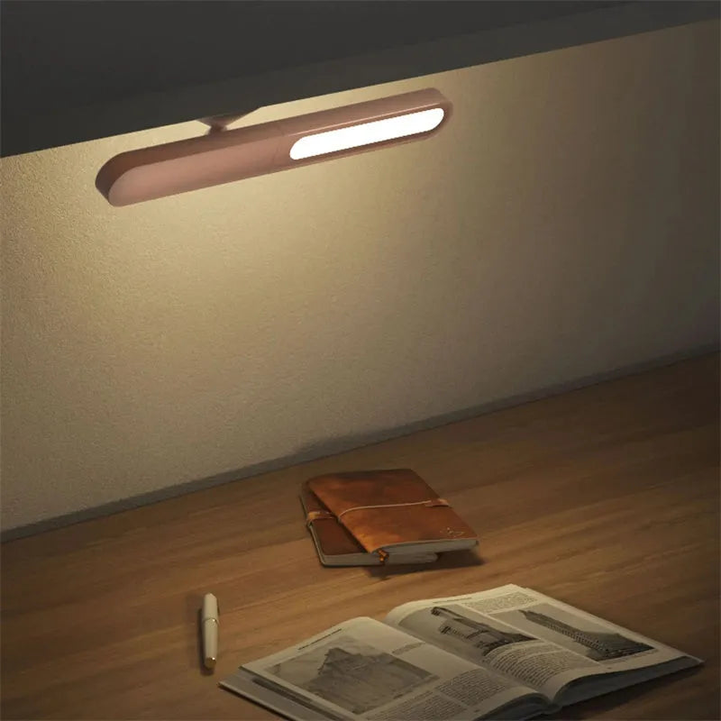 White geometric USB desk lamp with magnetic base shown on a wooden desk.