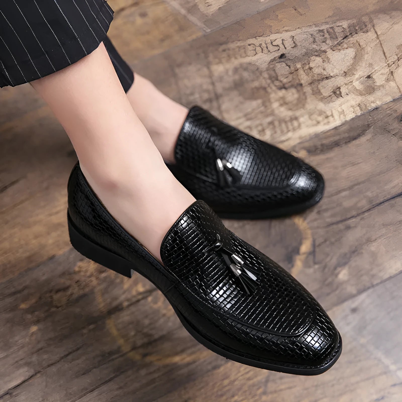 Men's black pointed slip-on business shoes with tassel detail on artificial PU leather upper