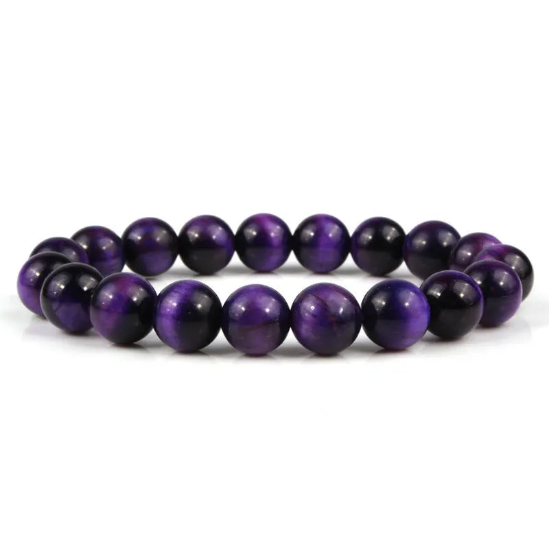 Tiger eye crystal stone bracelet showing round beads available in multiple colours and sizes on a wrist.