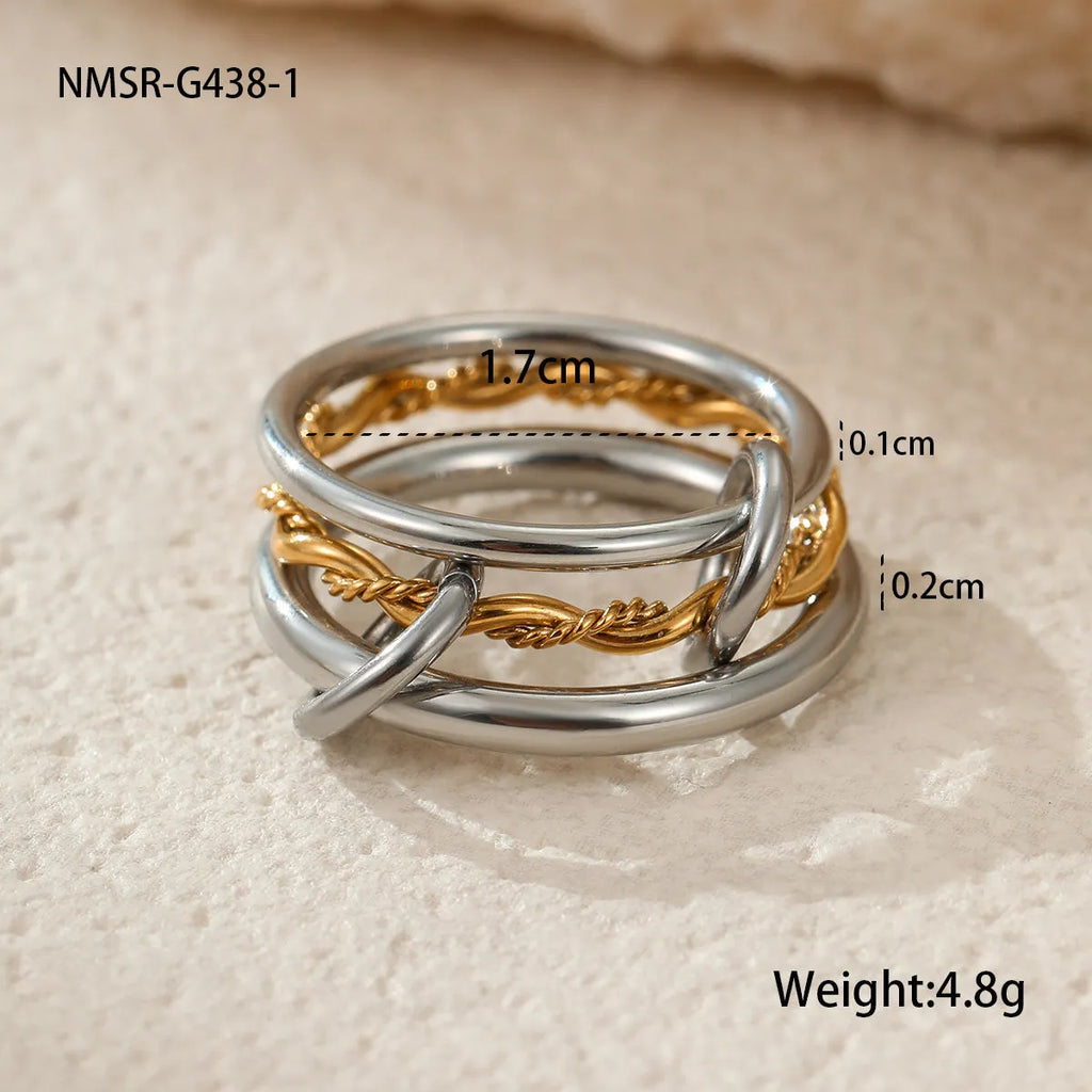 Stacked gold plated stainless steel ring set showing exaggerated design on a model's hand.