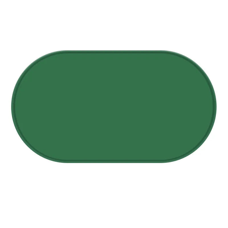 Silicone cat feeding placemat in green colour, shown under a food bowl on a wooden floor.