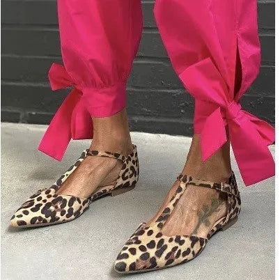 Women's leopard print pointed toe pumps with a chunky low heel and cross shoulder straps.
