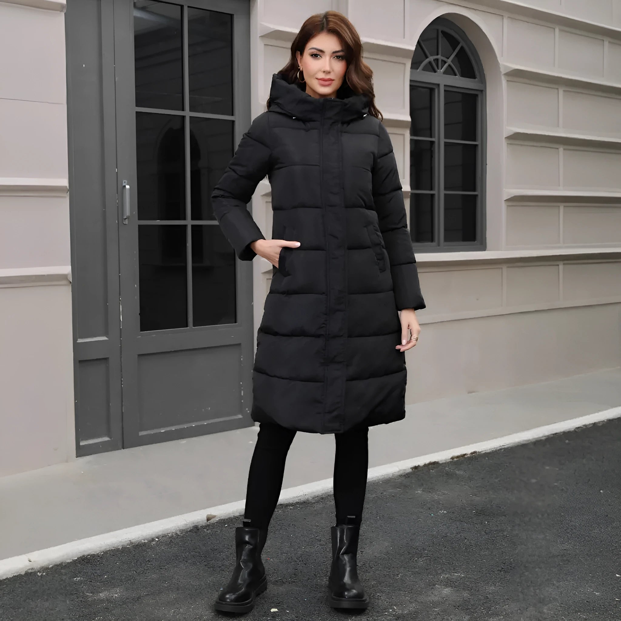 A black hooded slim-fit long jacket for men on a hanger.