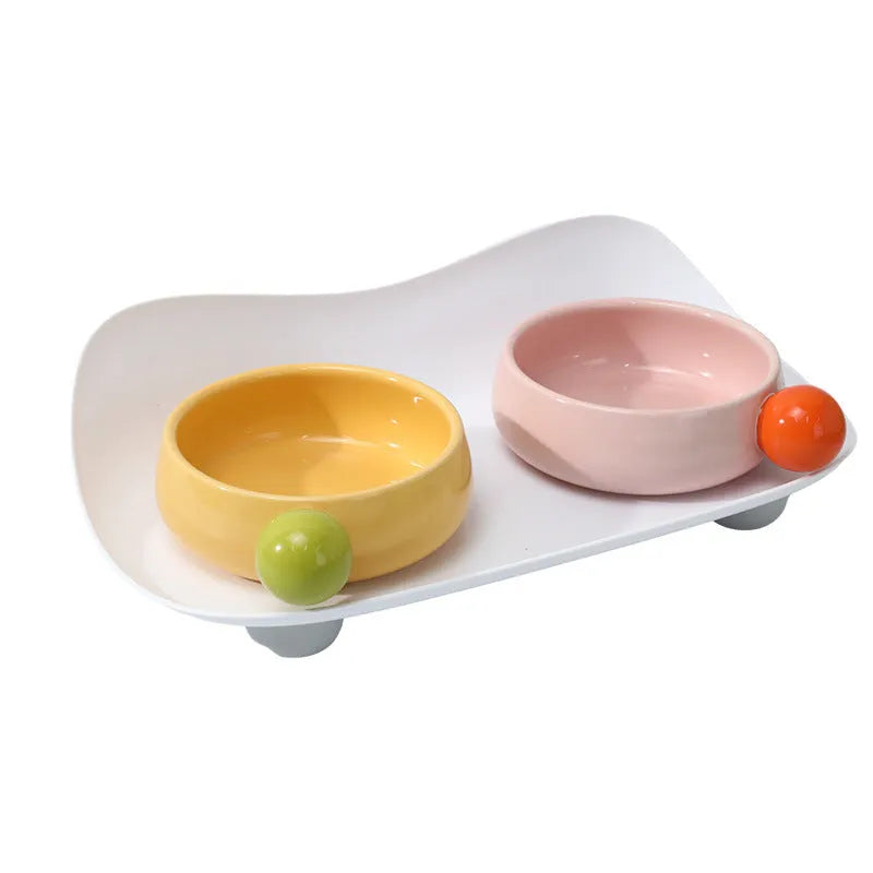 Ceramic raised pet feeding bowl set in pink with two bowls and non-slip base.