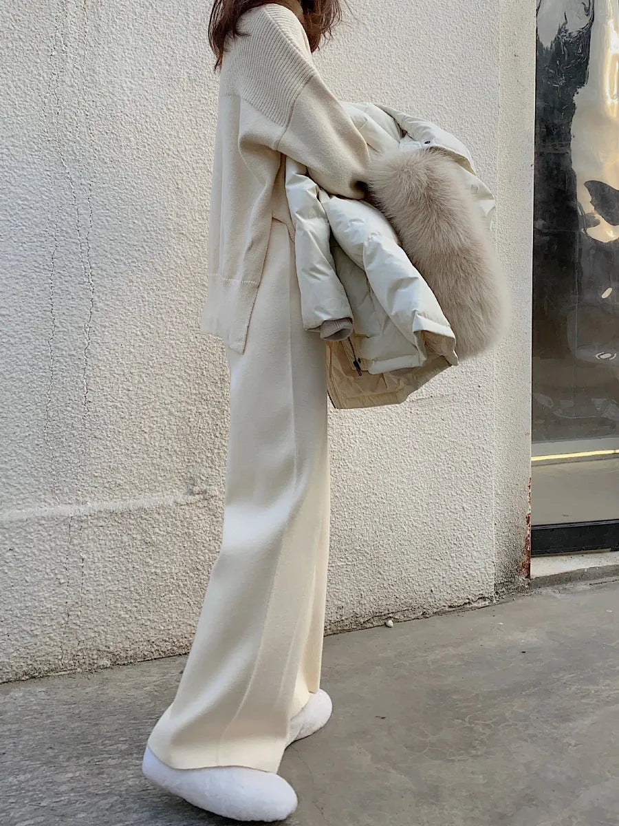 Woman wearing high waist cream white knitted wide-leg trousers with a straight, drooping mopping cut.