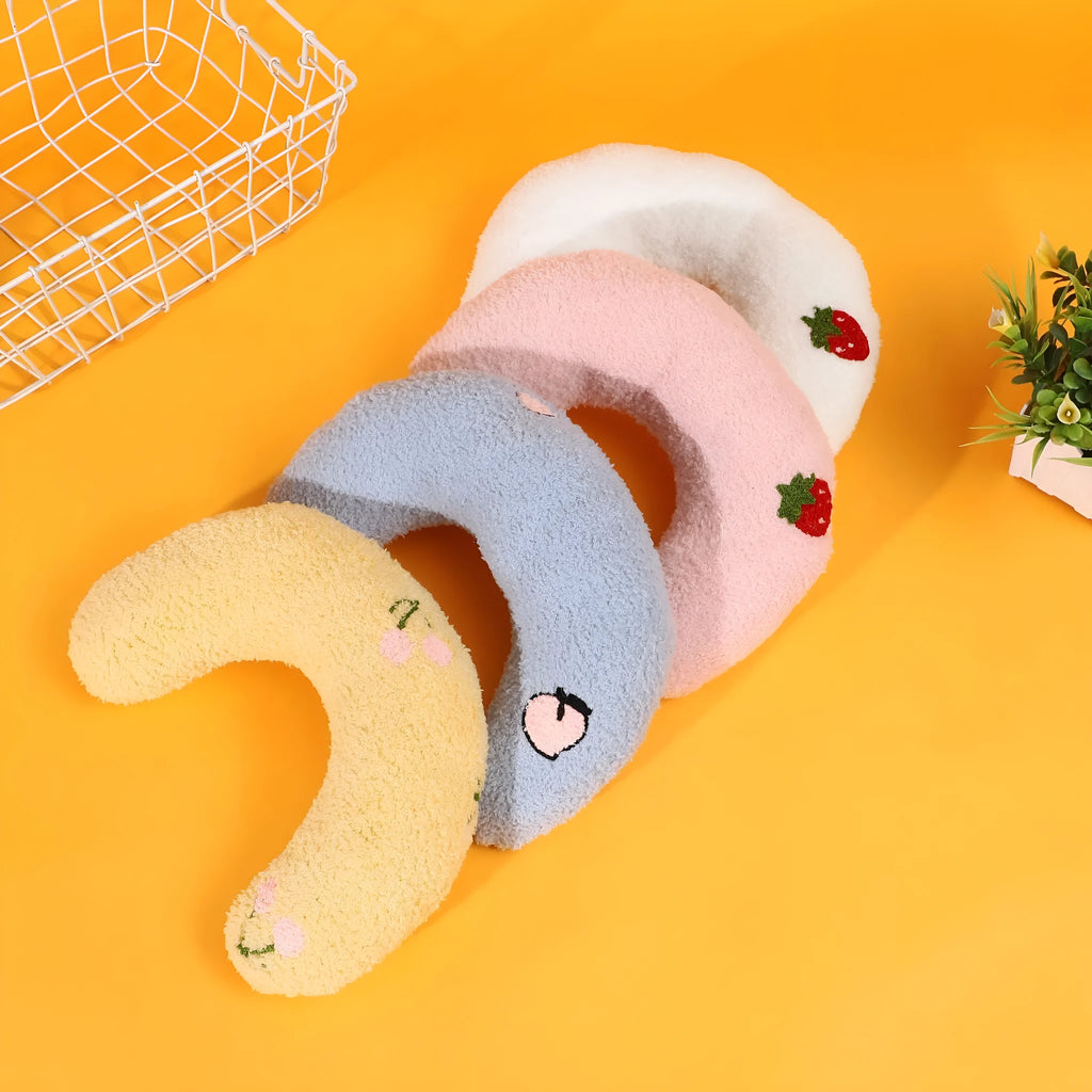 Blue U-shaped half moon cloth pillow for cats and dogs on a wooden floor.