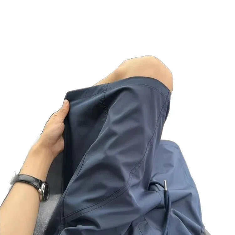 Men's beige quick-drying polyester sports shorts with elastic waistband, shown in a straight cut style.