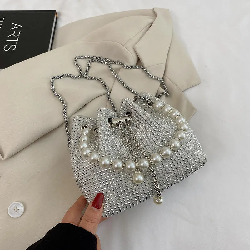 Women's soft PU light diamond decorated crossbody shoulder bag with chain strap in bucket shape.