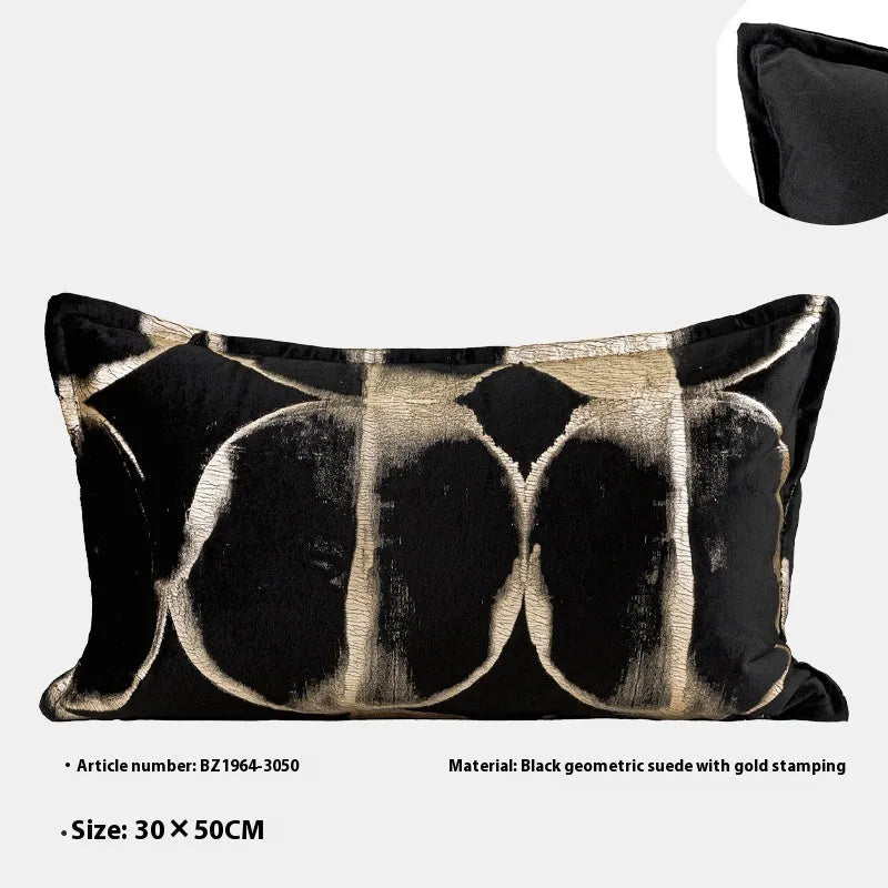 Black and gold abstract patterned flannel cushion in square and bolster sizes on a grey sofa.