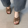 Women's light brown retro high heel sandals with thin cross straps and an ankle buckle on a square toe.