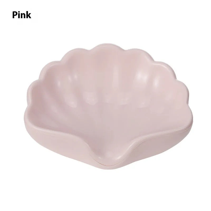 White or pink shell-shaped plastic soap dish for bathroom countertop.