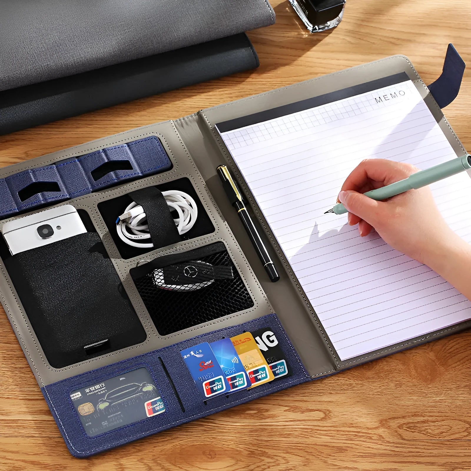 Black leather A4 business folder open to show document sleeve, pen loop, and notepad holder.